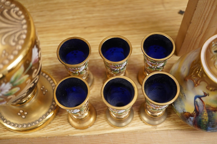 A Royal Worcester peacock painted jar and cover and a Bohemian blue glass decanter and six glasses, with gilt and enamel decoration, decanter 26cm high including stopper. Condition - finial to Worcester pot cover chipped